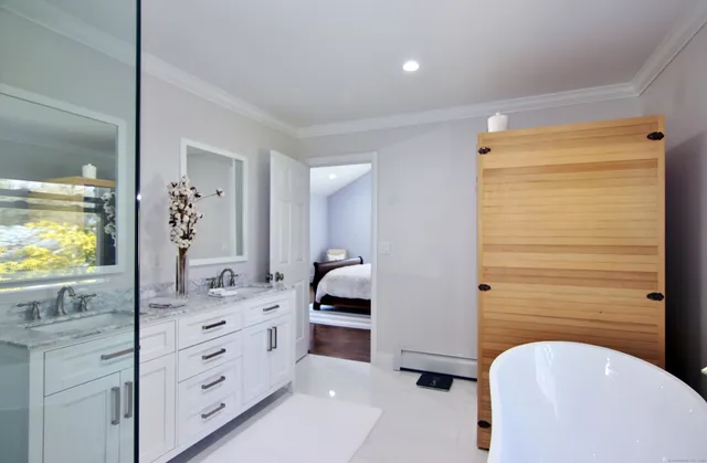 a en suite bathroom with a granite countertop sink and a mirror