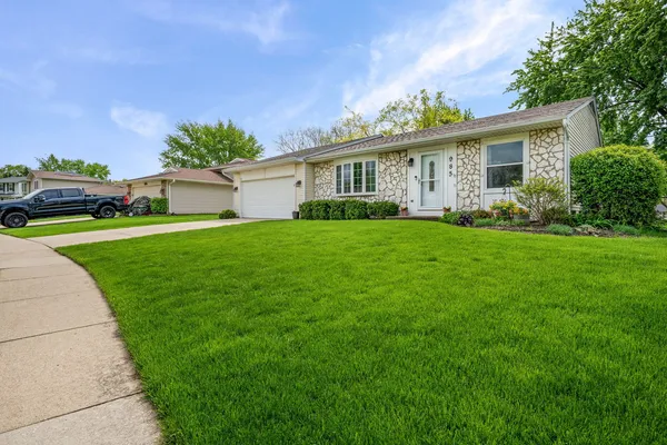 a front view of a house with a garden and yard
