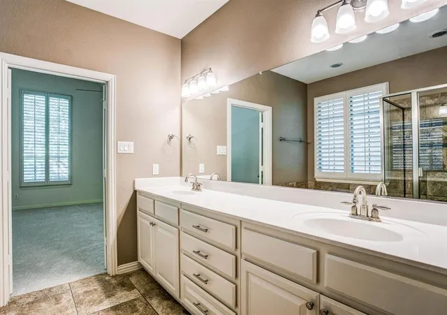a bathroom with double vanity sinks and a mirror