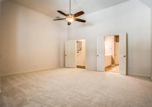 an empty room with closet and a ceiling fan
