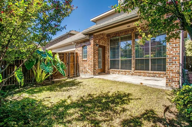a view of house with backyard and glass windows