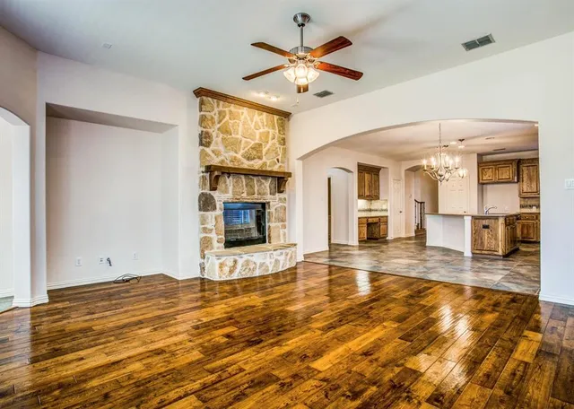 an empty room with wooden floor and a fireplace