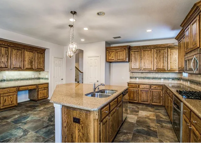 a kitchen with granite countertop a sink stove and cabinets