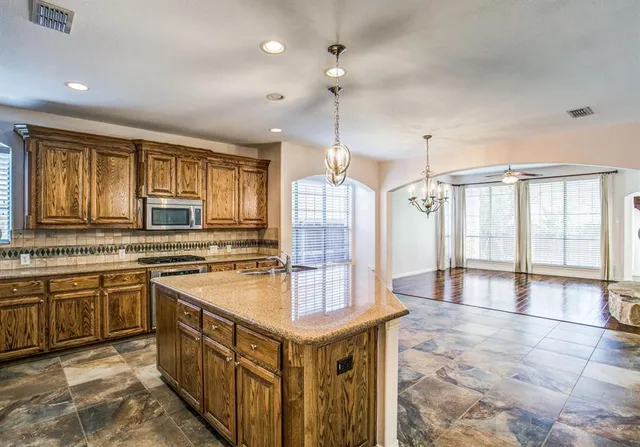 a large kitchen with stainless steel appliances granite countertop a sink and a stove