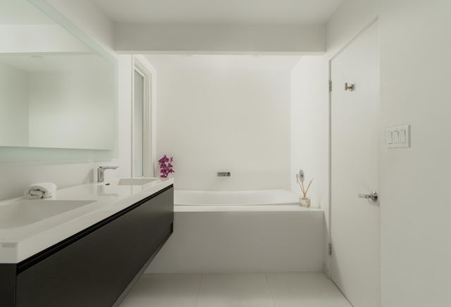a bathroom with a bathtub sink vanity and mirror