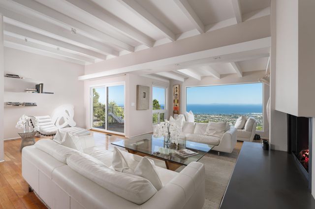 a living room with furniture wooden floor and a large window
