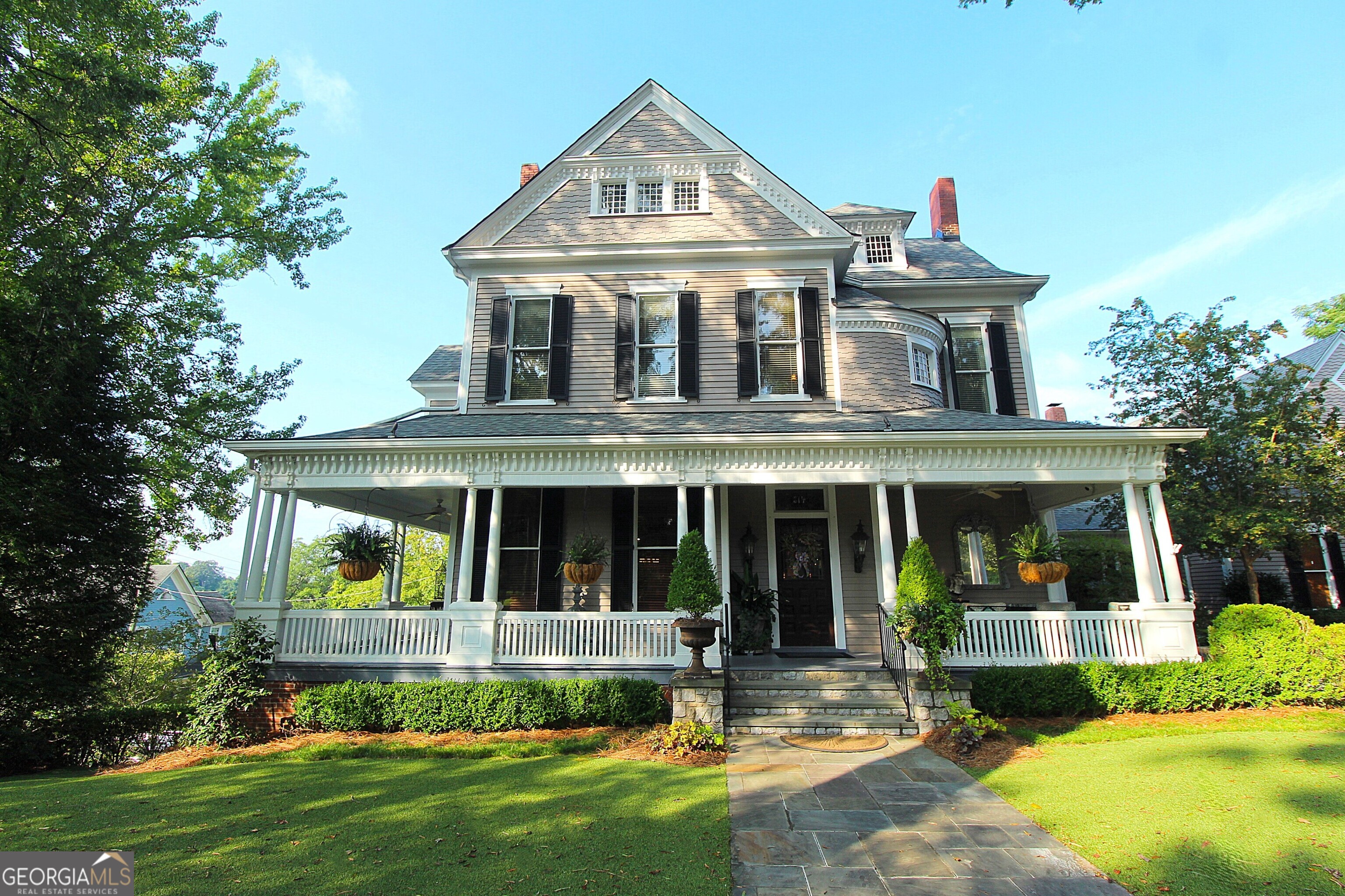 320 East 3rd Avenue Rome, GA 30161 - Photo 3 of 152 a view of a white house with a large windows and a yard with plants and large trees