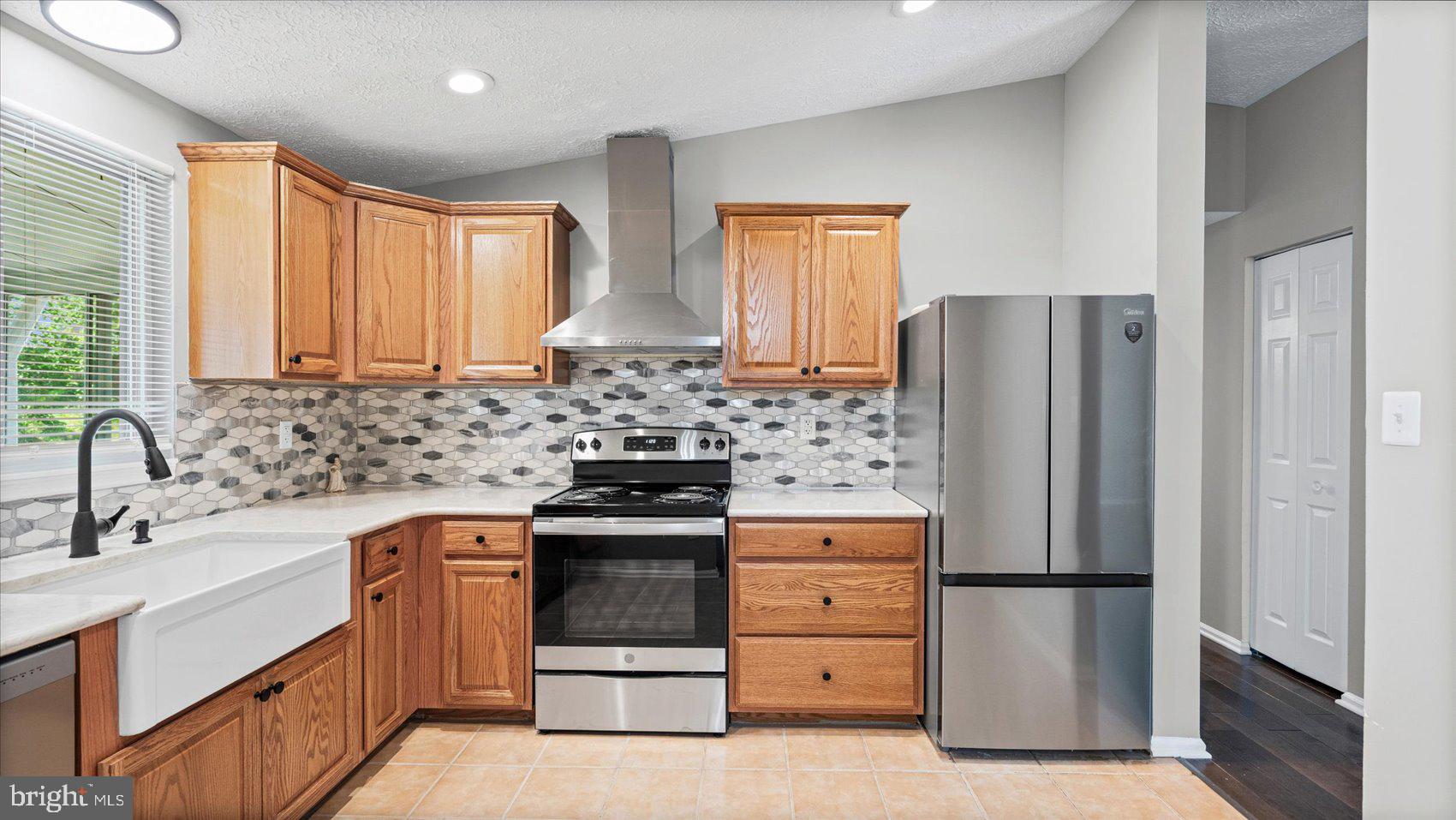 3709 Redberry Way Nottingham, MD 21236 - Photo 12 of 45 a kitchen with stainless steel appliances a refrigerator sink and cabinets