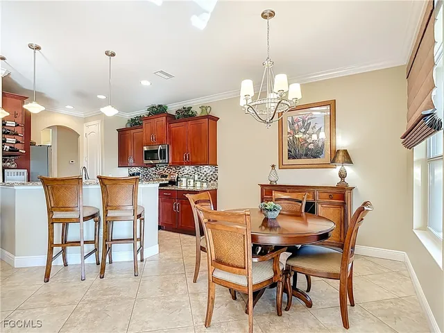 a dining room filled a chandelier a table and chairs