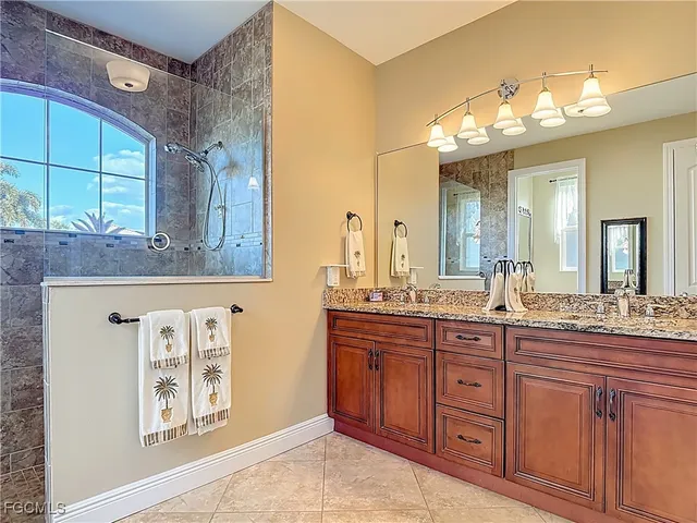 a bathroom with a granite countertop sink a large mirror and a window