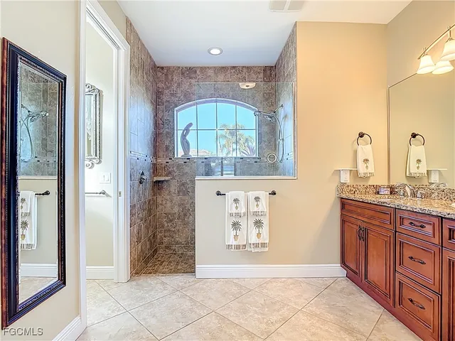 a bathroom with a granite countertop sink a mirror and a shower