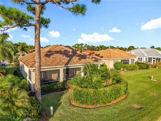 a view of a white house with a big yard and potted plants