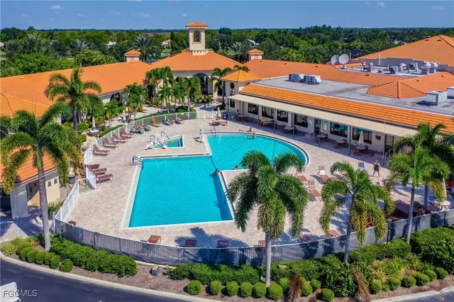 an aerial view of a swimming pool with a table and chairs under an umbrella