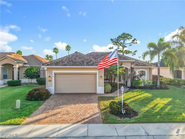 a front view of a house with a yard and potted plants