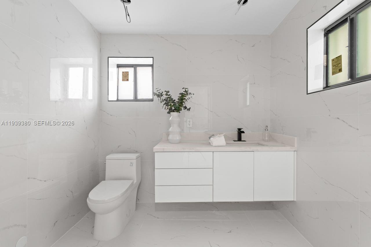 1741 Southwest 17th Court Miami, FL 33145 - Photo 15 of 19 a bathroom with a sink a toilet and mirror