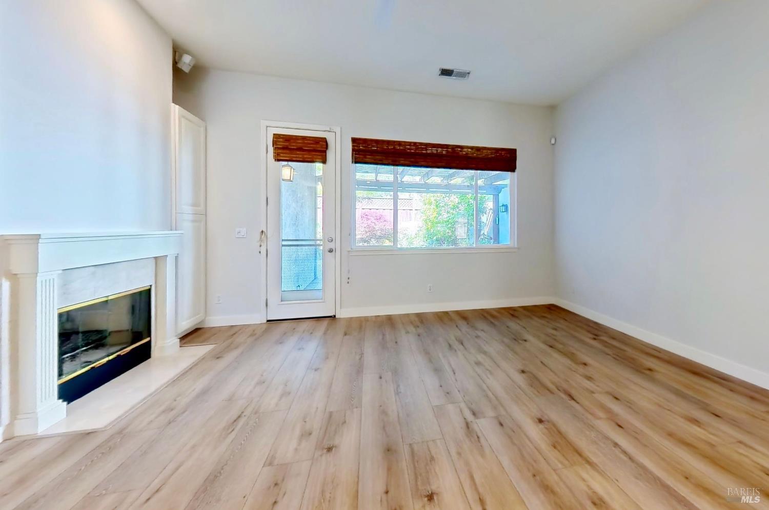 844 Signorelli Circle St. Helena, CA 94574 - Photo 13 of 32 an empty room with wooden floor fireplace and windows