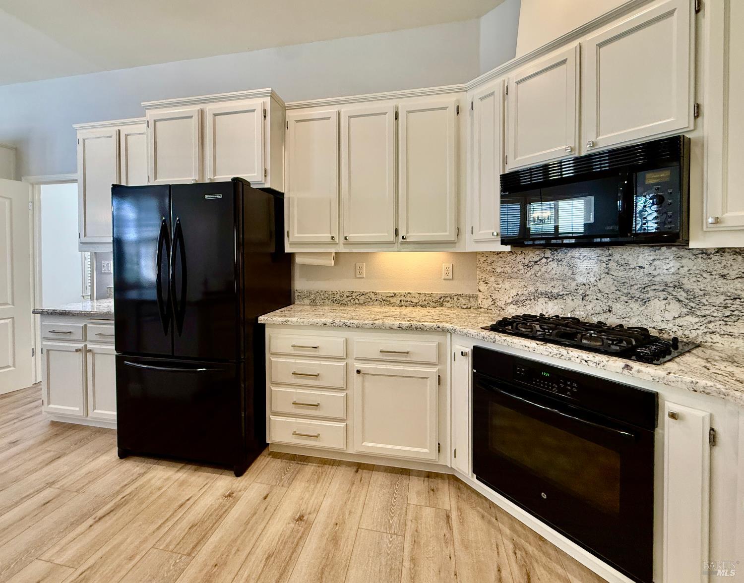 844 Signorelli Circle St. Helena, CA 94574 - Photo 7 of 32 a kitchen with granite countertop a refrigerator stove and microwave