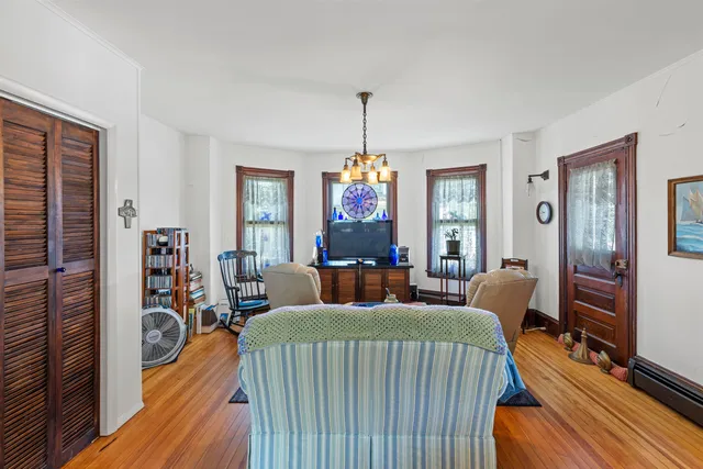 a living room with furniture a fireplace and a chandelier
