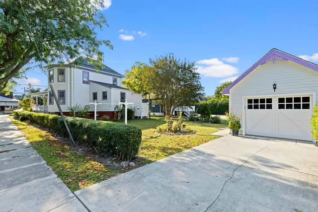a view of a house with a yard and potted plants
