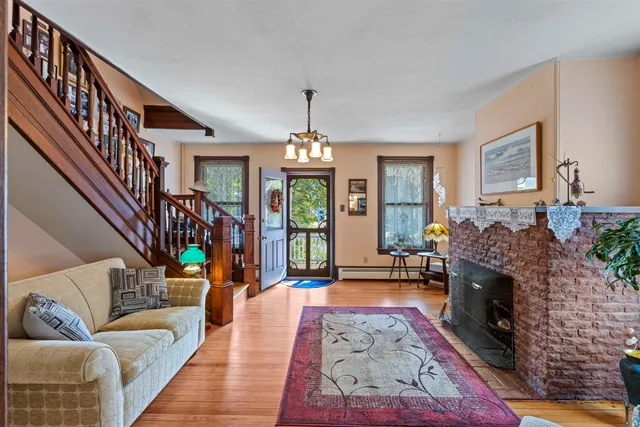 a living room with furniture a fireplace and a chandelier