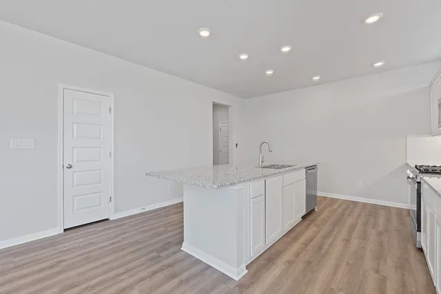 a kitchen with a sink and wooden floor