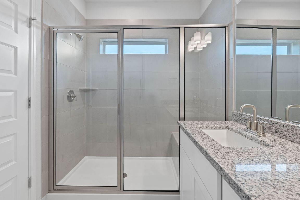 376 Blue Oasis Lane Leander, TX 78641 - Photo 19 of 27 a bathroom with a granite countertop sink mirror and shower