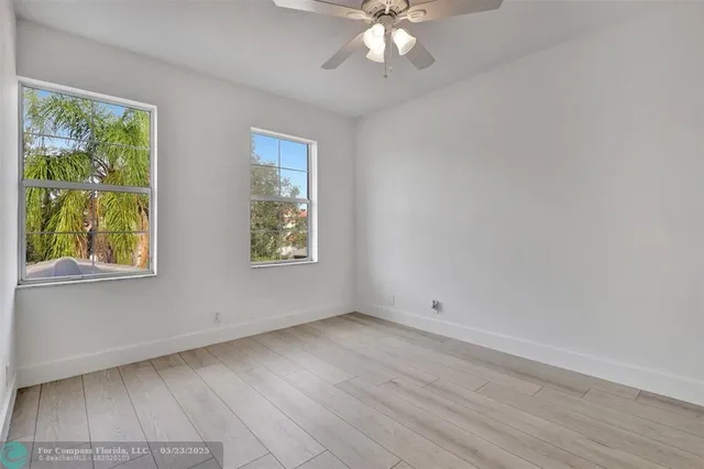 a view of an empty room with a chandelier fan