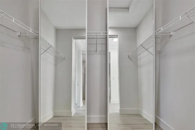 an empty room with closet and a ceiling fan