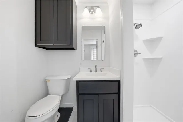 a bathroom with a toilet a sink and mirror