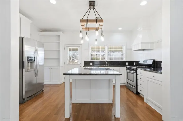 a kitchen with stainless steel appliances granite countertop a stove and a refrigerator