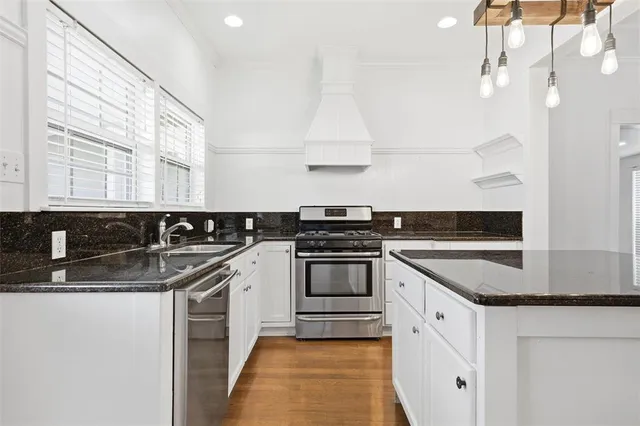 a kitchen with stainless steel appliances granite countertop a sink and a stove
