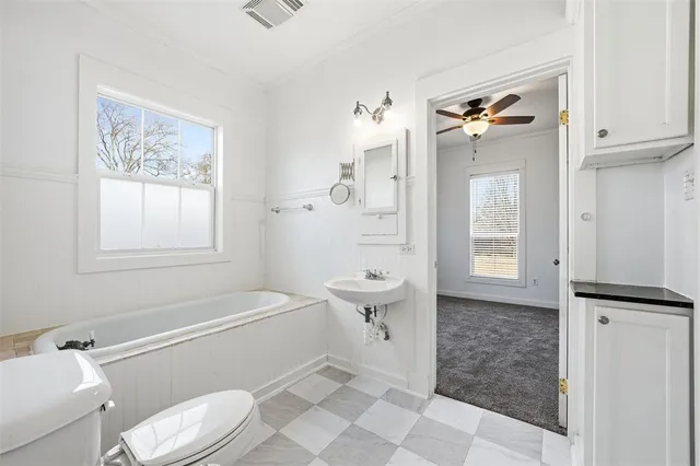 a bathroom with a toilet a sink a shower and mirror