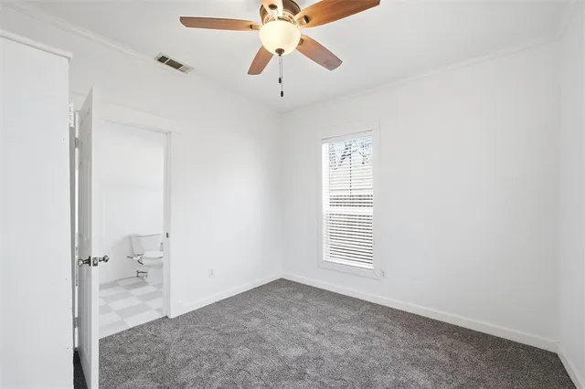 a view of a room with a ceiling fan and bathroom