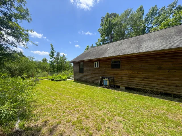 a view of a house with pool and a yard