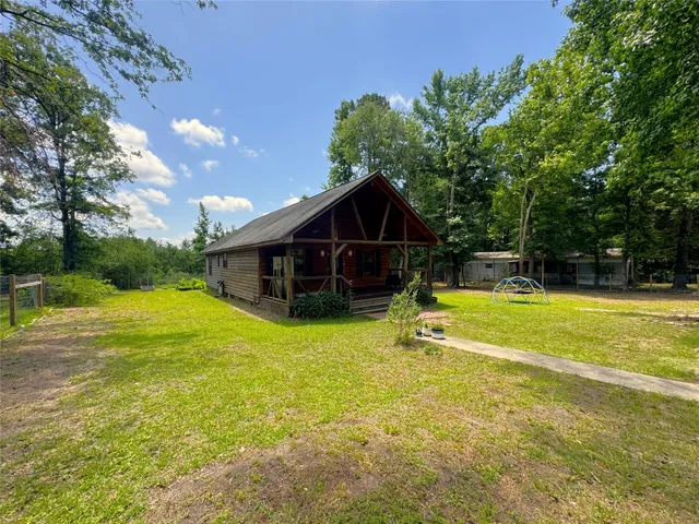 an aerial view of a house with a yard and large trees