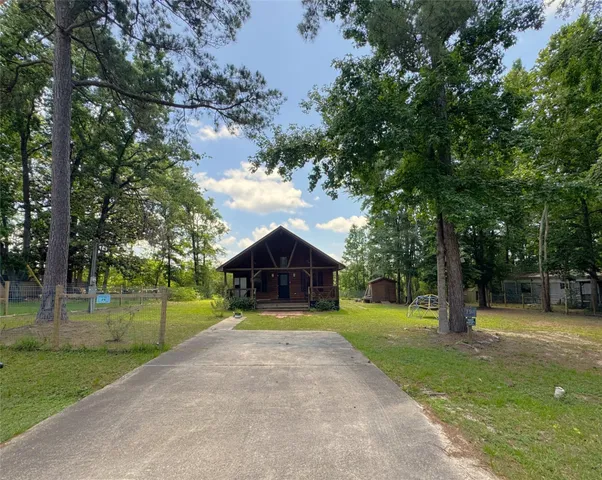 a view of a park with large trees and a barn in it