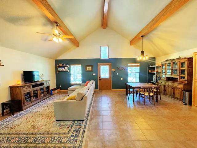a living room with patio furniture and a flat screen tv