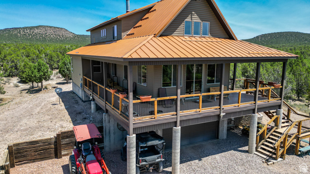 1342 North Old Hebron Road Enterprise, UT 84725 - Photo 47 of 67 Back of house with an attached garage, a metal roof, a deck with mountain view, and gravel driveway