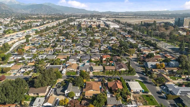 an aerial view of residential houses with outdoor space and trees