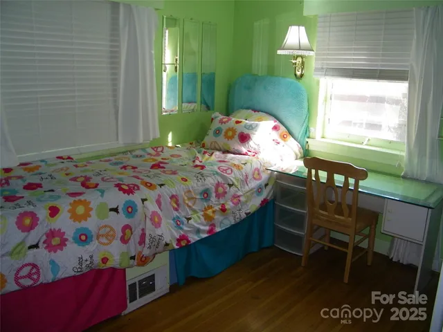 a bedroom with two beds and a potted plant