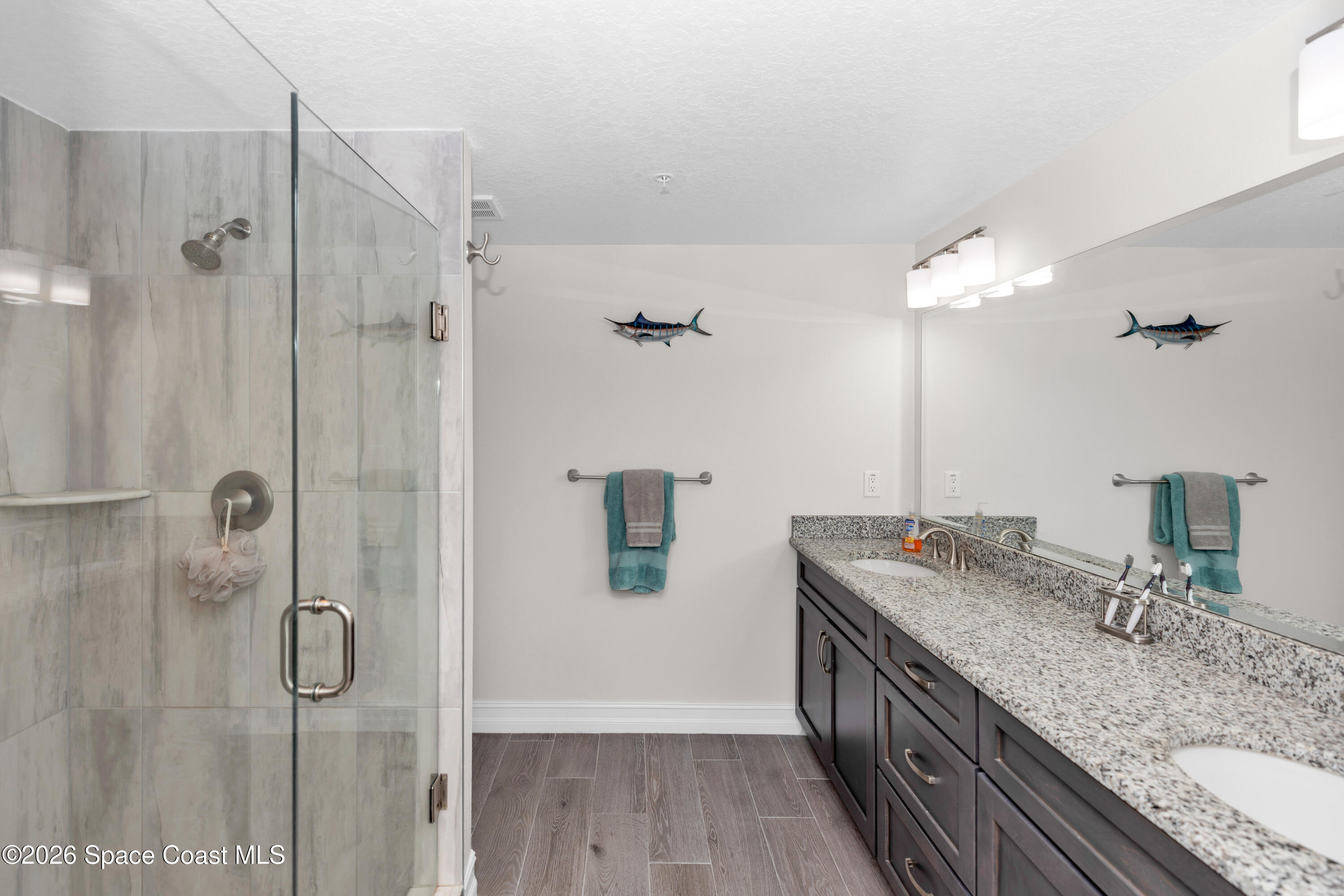 1805 Riverside Drive, Unit 506 Titusville, FL 32780 - Photo 15 of 24 a bathroom with a granite countertop double vanity sink a mirror and shower