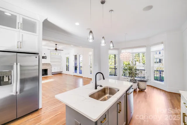 a kitchen with sink refrigerator and large window