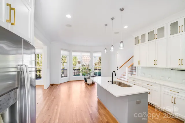 a view of kitchen with sink and refrigerator