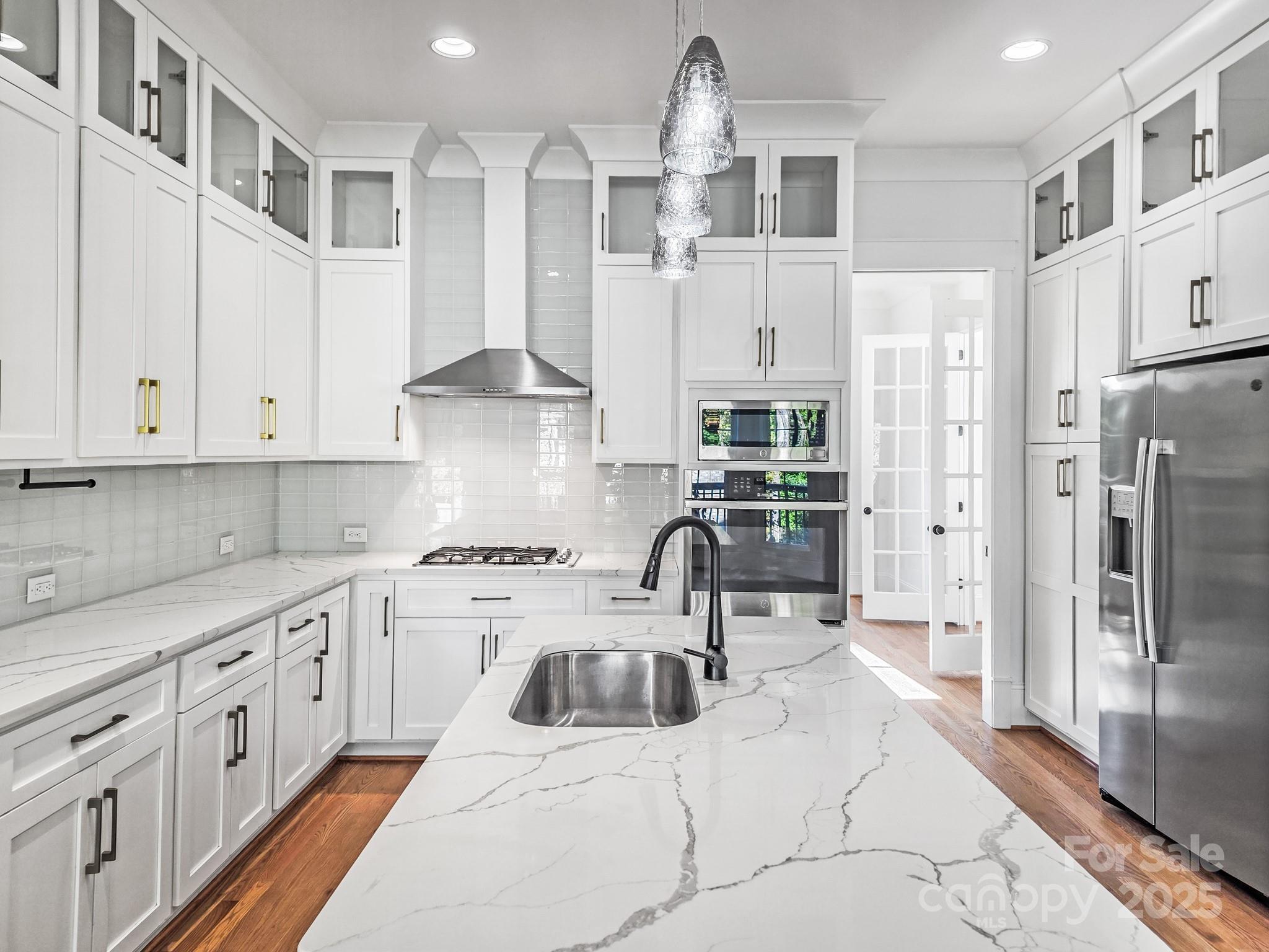 6541 Gardner Lane Charlotte, NC 28270 - Photo 19 of 47 a kitchen with stainless steel appliances kitchen island granite countertop a refrigerator a sink dishwasher a stove and white cabinets with wooden floor