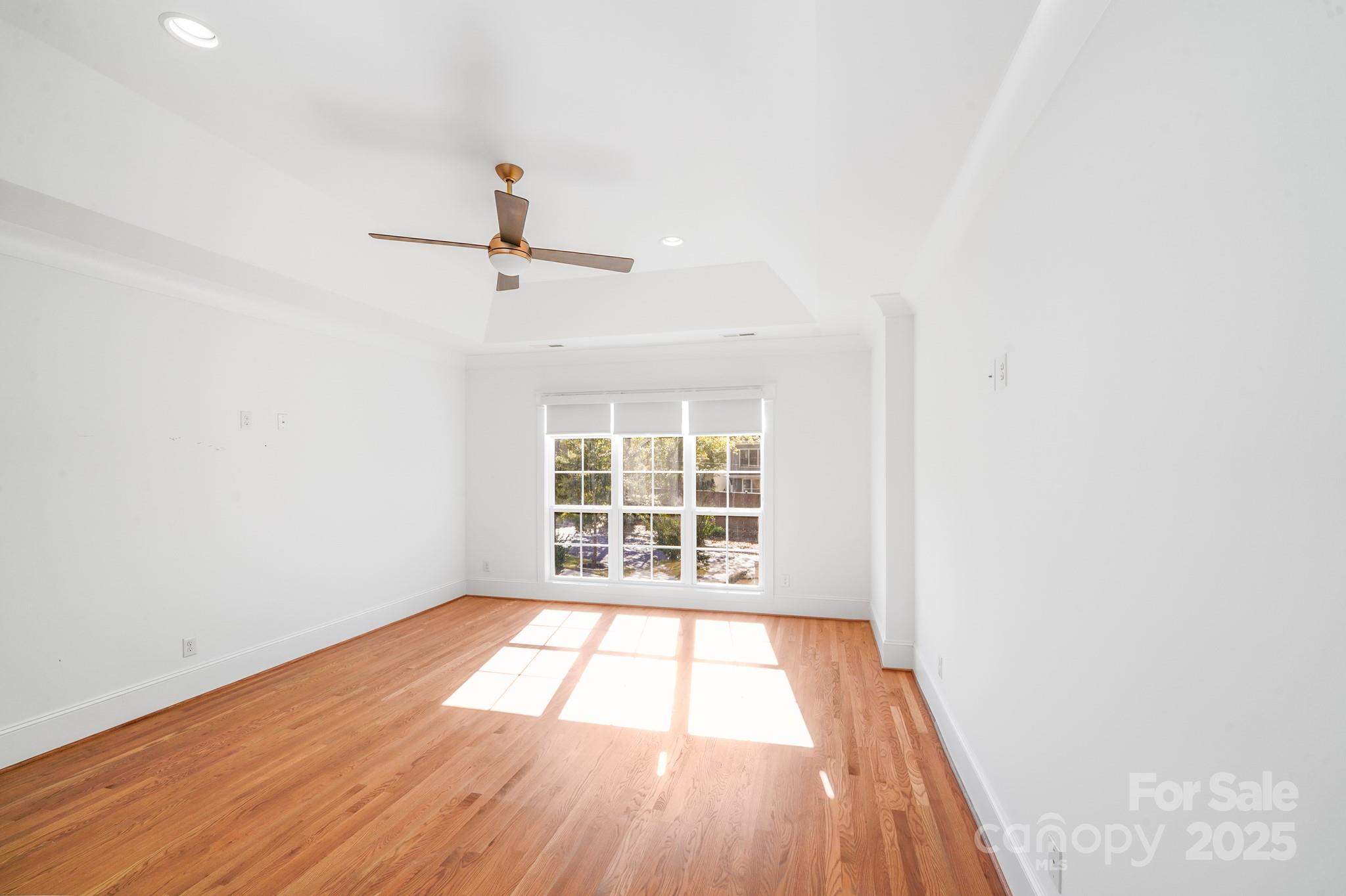 6541 Gardner Lane Charlotte, NC 28270 - Photo 30 of 47 an empty room with wooden floor ceiling fan and windows