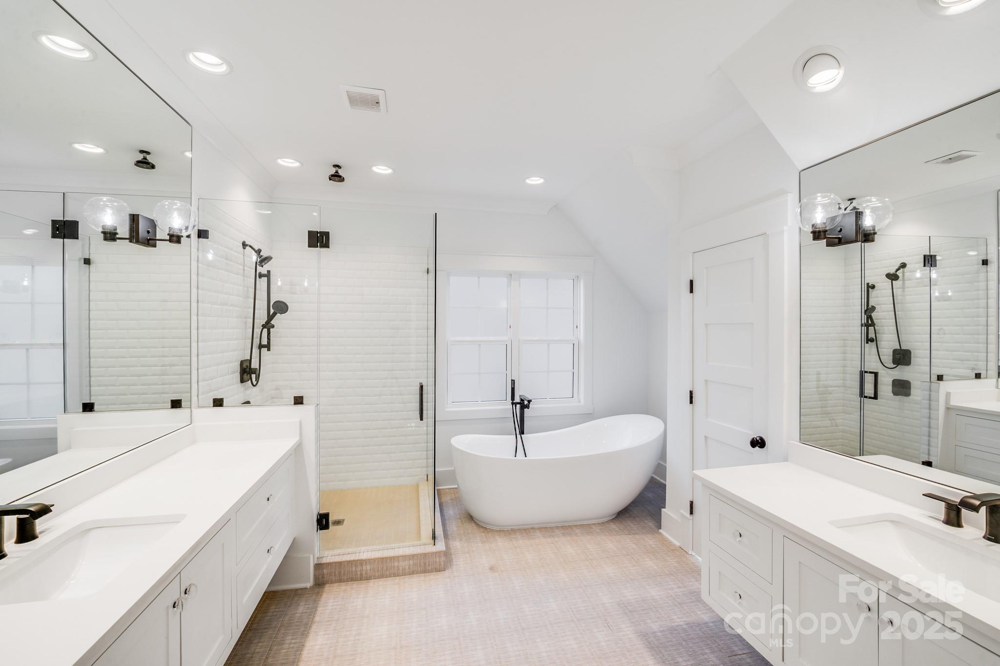 6541 Gardner Lane Charlotte, NC 28270 - Photo 33 of 47 a spacious bathroom with a double vanity sink a mirror and a bathtub