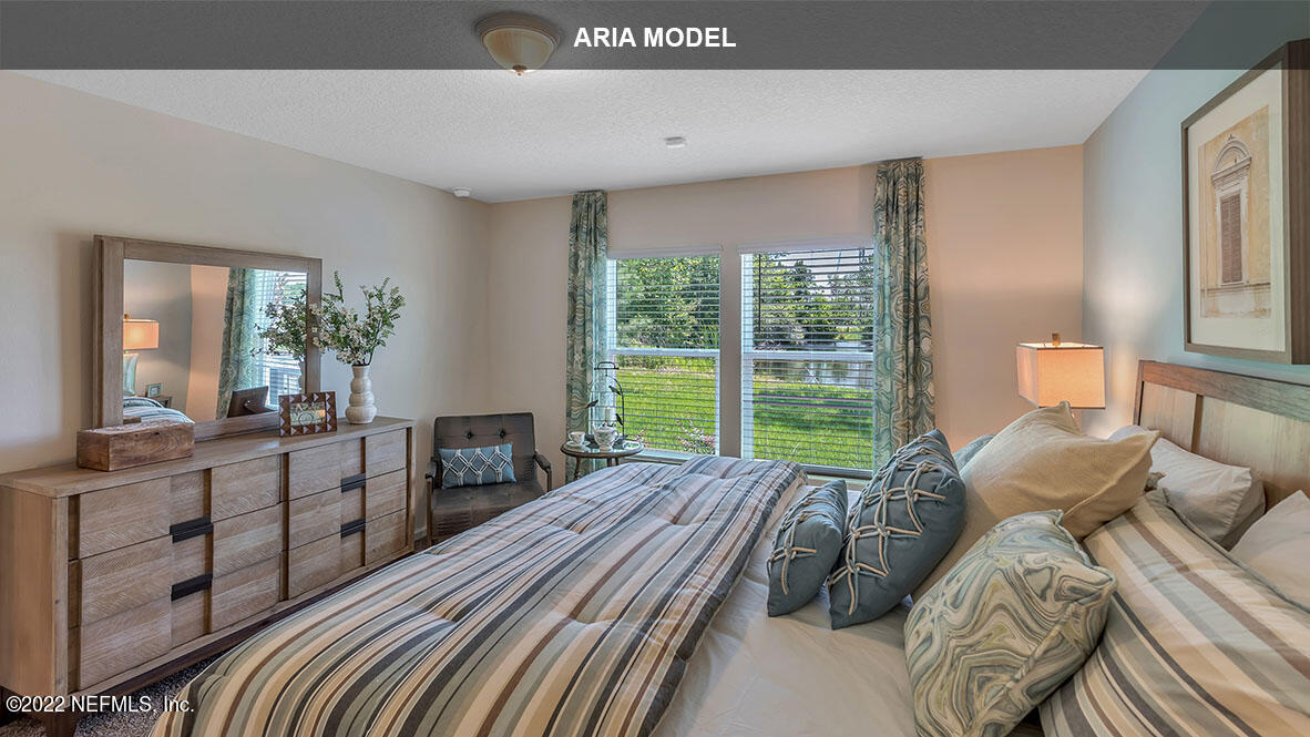 65458 River Glen Parkway Yulee, FL 32097 - Photo 14 of 47 a large bedroom with a bed and large windows