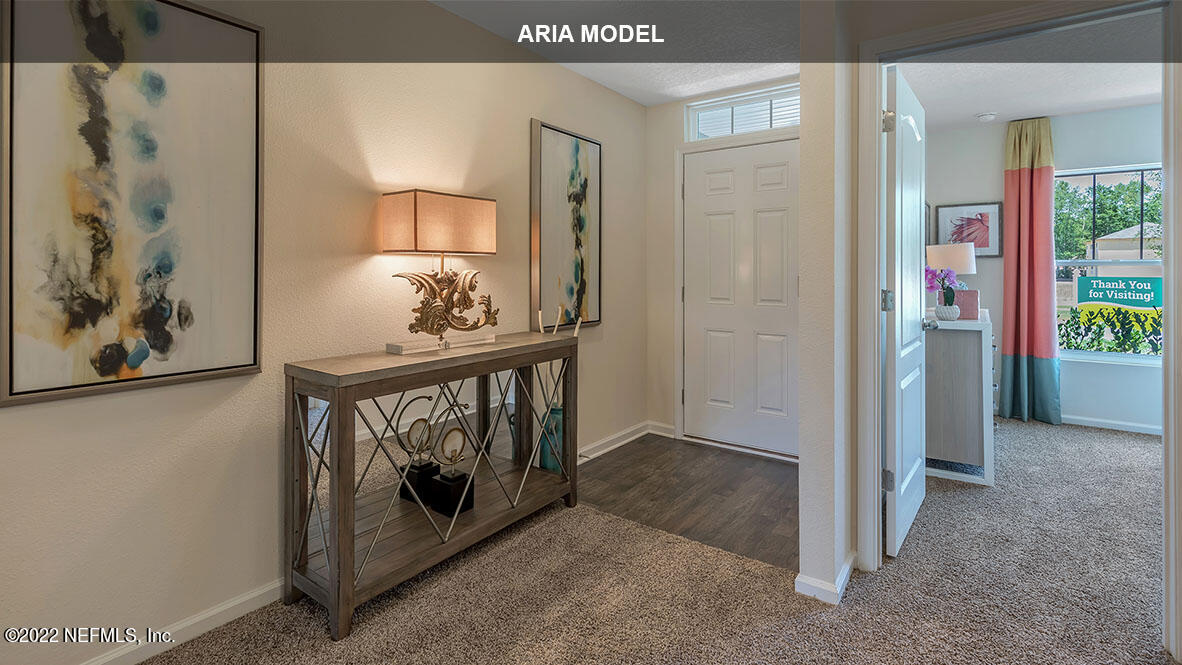 65458 River Glen Parkway Yulee, FL 32097 - Photo 5 of 47 a view of a hallway to a room with bed and a painting on the wall