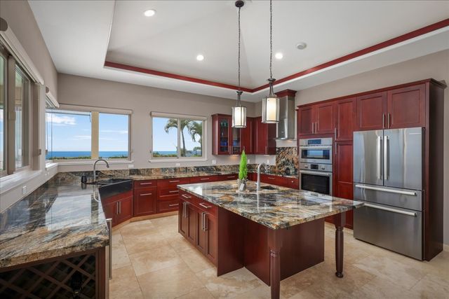 a kitchen with stainless steel appliances granite countertop a stove refrigerator and a sink