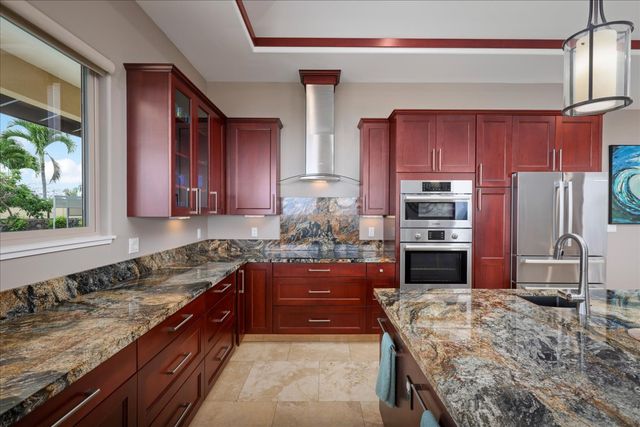 a kitchen with stainless steel appliances granite countertop wooden cabinets a stove a sink and a granite counter tops